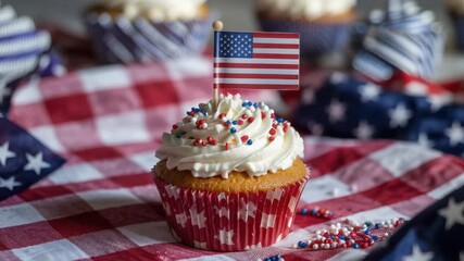 Festive celebration cupcake decorated with American flag and patriotic sprinkles on checkered tablecloth for holiday party or event promotion