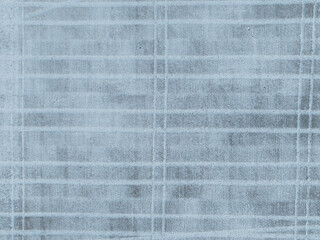 Aerial top-down drone view of a snowy field in Estonia, with distinctive tractor tracks creating...