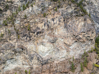 Rugged Mountain Cliff Face With Sparse Trees and Weathered Rock Formations in BC, Canada