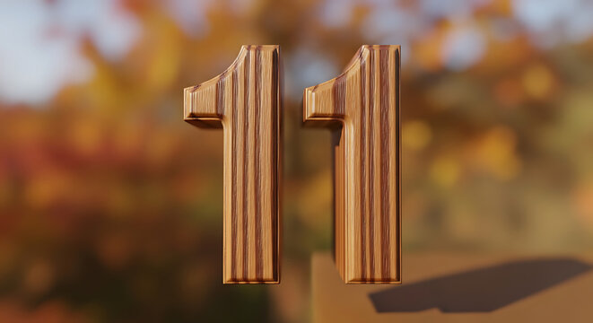 Wooden number eleven against a blurred background of autumn leaves