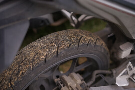 Rugged motorcycle tire caked with dirt, symbolizing resilience and the thrill of outdoor exploration, capturing the essence of adventurous journeys on unpaved paths