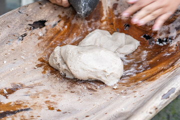 Poi or popoi is a traditional staple food in the Polynesian diet, made from taro.  Waiahole Poi Factory, Honolulu, Oahu, Hawaii. pounding taro / hand pound poi.