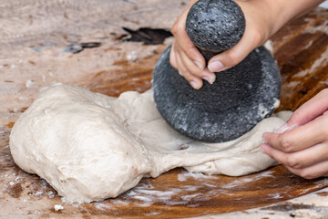 Poi or popoi is a traditional staple food in the Polynesian diet, made from taro.  Waiahole Poi Factory, Honolulu, Oahu, Hawaii. pounding taro / hand pound poi.