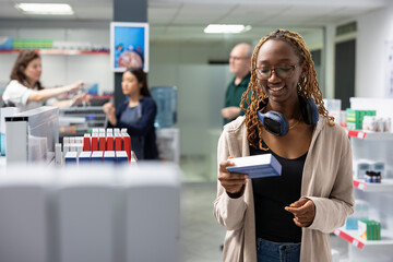 African american patient looks at shelves filled with medical capsules, examining medical supplies in retail pharmacy shop, relying on labels for accurate healthcare assistance and self care.