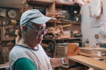 Senior craftsman diligently building wooden furniture in workshop