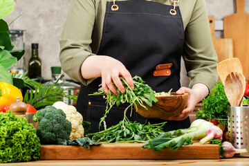 skilled private chef prepares variety of fresh vegetables and herbs in a well-equipped kitchen, focusing on healthy meal preparation