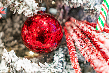 Large red bauble with silver glitter, small red baubles, candy canes, Christmas decorations, festive mood, contrasting colors, dynamic arrangement, bright lighting, vibrant atmosphere, realistic styl