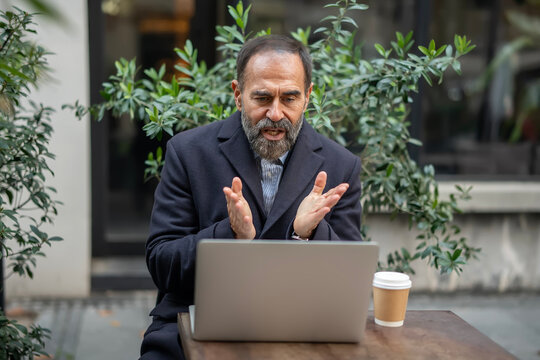 Mature businessman actively discussing during a virtual meeting - Powered by Adobe