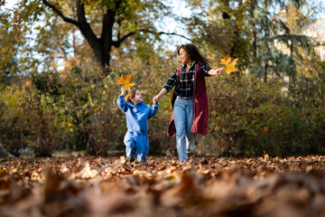 Mother and child with down syndrome playing in autumn park
