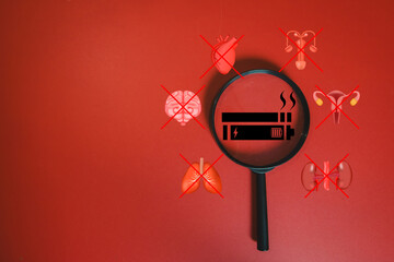 Dangers of Vaping. Magnifying glass on e-cigarette icon with damaged organs (heart, lungs, brain, kidney). Health risk and anti-smoking concept. Red background with copy space.