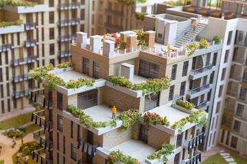 Obraz premium Model of a multi-storey residential building with plants on the terraces. Architecture