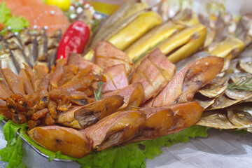Different varieties of salted and smoked fish on the counter of a fish store