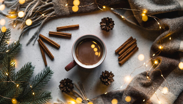 Cozy flat lay of a cup of coffee surrounded by pine cones, cinnamon sticks, and fairy lights, creating a warm and inviting winter atmosphere.