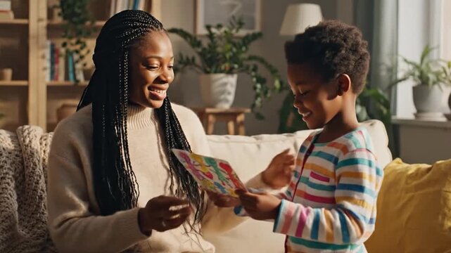 Heartwarming Moment: Young Boy Presents Homemade Card to His Mother, Embracing Love