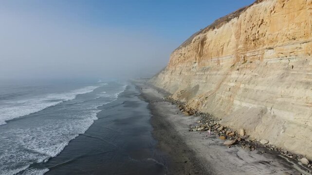 Aerial Drone View of Torrey Pines Coastline at Sunrise, Foggy Morning with Foamy Ocean Waves