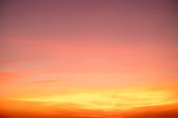 Sunset or sunrise sky with a vibrant gradient of orange, gold, and soft blue. Clear atmosphere with wispy clouds. Peaceful, natural light background. hope, freedom, new day and inspirational Concepts