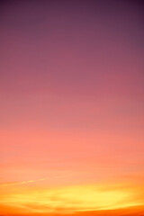 Sunset or sunrise sky with a vibrant gradient of orange, gold, and soft blue. Clear atmosphere with wispy clouds. Peaceful, natural light background. hope, freedom, new day Concepts, Vertical