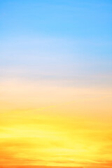 Sunset or sunrise sky with a vibrant gradient of orange, gold, and soft blue. Clear atmosphere with wispy clouds. Peaceful, natural light background. hope, freedom, new day Concepts, Vertical