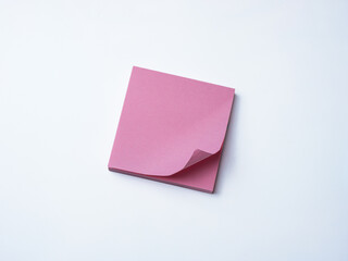 Single pink sticky note pad with curled corner placed on a clean white background. 