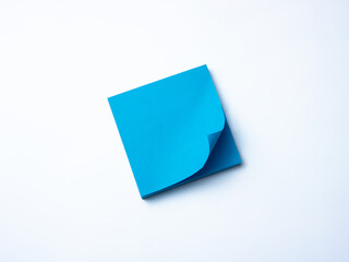 Single blue sticky note pad with curled corner placed on a clean white background. 