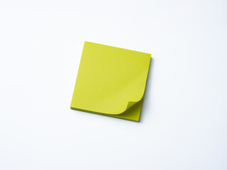 Single yellow sticky note pad with curled corner placed on a clean white background.