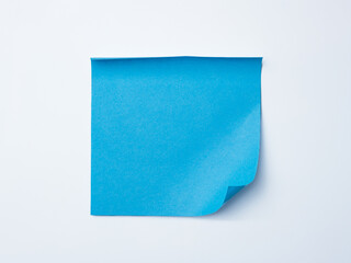 Single blue sticky note with curled corner placed on a clean white background.