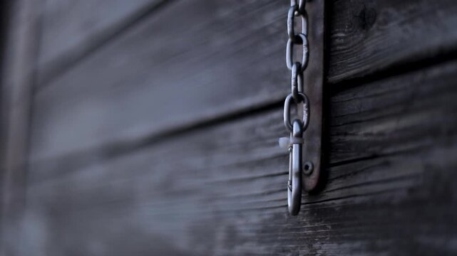 Close-up of a rusty Metal chain on a dark wood texture surface