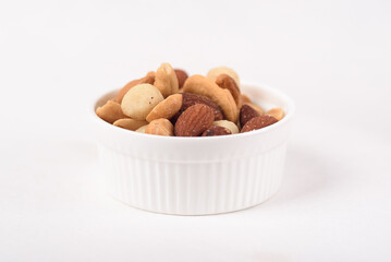 Mixed nuts consisting of almonds, cashews and peanuts, roasted with salt. Healthy snack on white background.