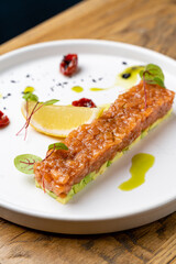 Savor a beautifully presented tartare made from fresh ingredients, garnished with colorful herbs and a lemon wedge, inviting you to enjoy a delightful culinary experience