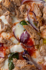 A mouthwatering pizza showcases a blend of tender pulled pork, creamy cheese, and colorful vegetables like red onion and fresh basil. Perfectly baked for a rich flavor