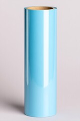 A close-up of a glossy blue vinyl roll standing upright on a neutral background, showcasing smooth texture and reflective surface