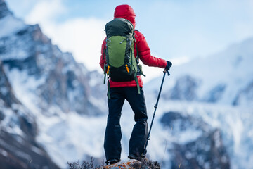 Backpacking woman hiking on winter high altitude mountain top