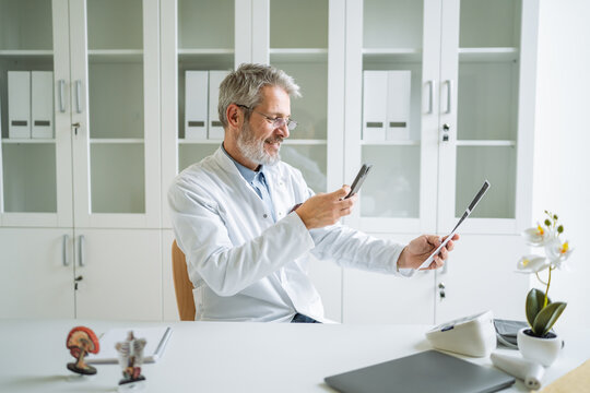 Doctor discussing medical imaging via medicine on smart phone