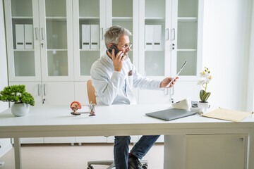 Senior doctor making medicine consultation using mobile phone