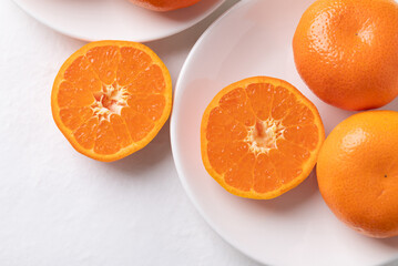 Mandarin orange fruit on white plate with white background, Top view