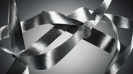 Intertwined, metallic ribbon-like forms swirl against a gradient gray background - Powered by Adobe