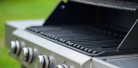 Modern Stainless Steel Barbecue Grill with a Lid Ajar, Revealing Clean Grates A sleek, modern stainless steel barbecue grill, captured at a slight angle. The lid is propped open just enough to reveal