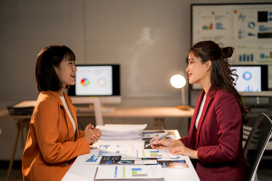 Businesswomen discussing data analysis during a late office meeting - Powered by Adobe