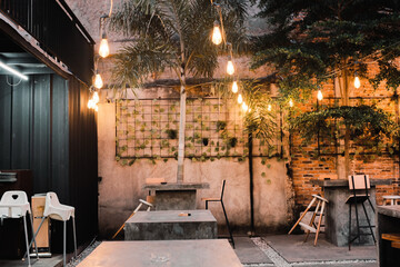 Outdoor Cafe with String Lights, Palm Tree and Brick Wall for Relaxation and Dining Experience
