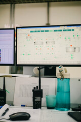 Monitoring System Display Control Room Desk with Radios, Water Bottle and Computer Screens