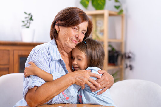 Grandmother and young girl share warm embrace at home, expressing affection, emotional support, family bonding and caring connection