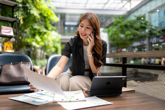 Asian businesswoman working remotely, making phone call