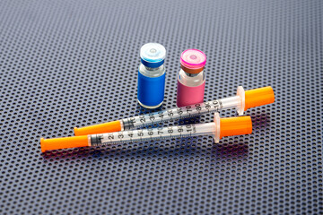 Single Use Syringes Next to Small Glass Vials