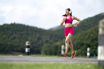 Woman running outdoors in sportswear with headphones