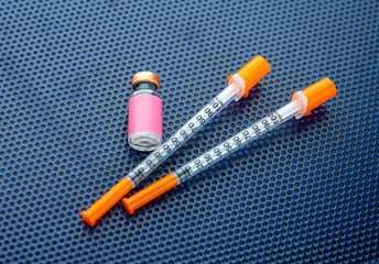 Single Use Syringes Next to Small Glass Vials