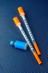 Single Use Syringes Next to Small Glass Vials