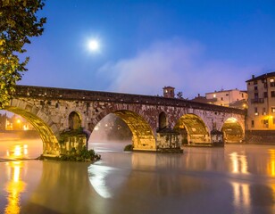 Obraz premium Vecchio ponte in pietra che attraversa un fiume in piena.