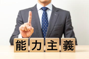 「能力主義」と書かれたブロックとビジネスマン