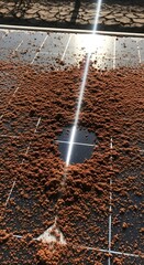 Close-up of a solar panel with dust and dirt particles on its surface, reflecting sunlight and showing the importance of maintenance for optimal energy efficiency