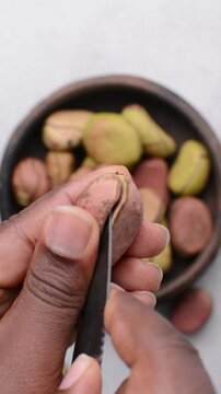 Overhead view of kola nut in hand, top view of fresh kolanut often used for religious ceremonies in african communities, process of breaking kola